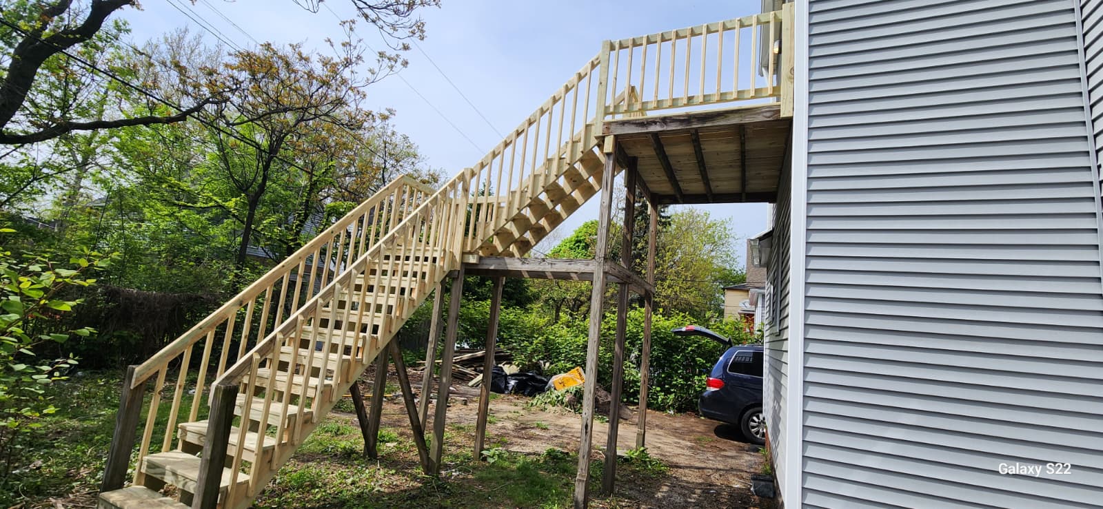 Exterior wood staircase and upper landing attached to a home