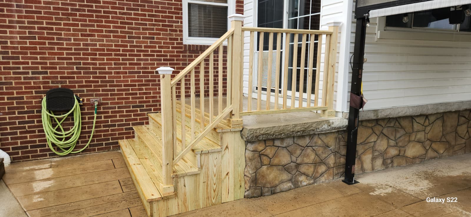 Freshly built wood entry steps and railing at a backyard door